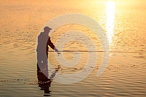 Male fisherman at dawn on the lake catches a fishing rod. Fishing hobby vacation concept. Copy space