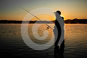 Male fisherman at dawn on the lake catches a fishing rod. Fishing hobby vacation concept. Copy space