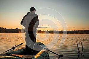 Male fisherman at dawn on the lake catches a fishing rod. Fishing hobby vacation concept. Copy space