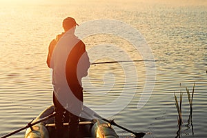 Male fisherman at dawn on the lake catches a fishing rod. Fishing hobby vacation concept. Copy space