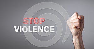 Male fist. Stop Violence text on gray background