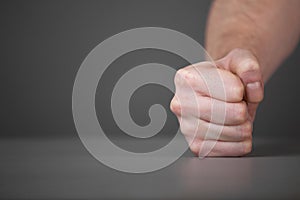 Male fist on the table.