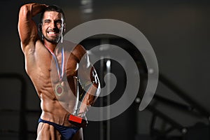 Male Fitness Competitor Showing His Winning Medal