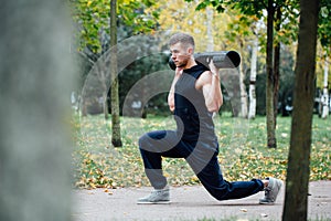 Male fitness doing exercise lunge with vipr, morning workout in the park.