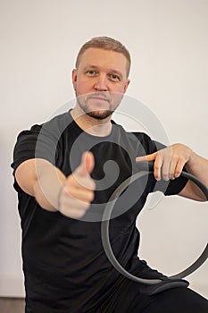 Male fitness Pilates trainer shows exercises on special simulators. Rubber rings for stretching
