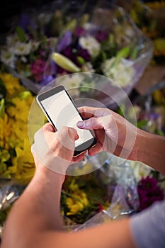 Male florist text messaging on mobile phone