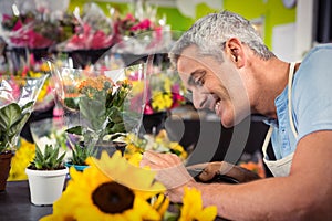 Male florist trimming stems of flowers at flower shop