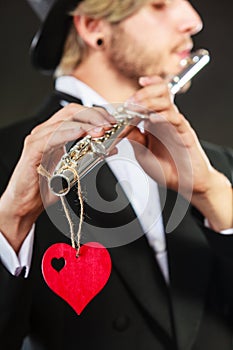 Male flutist with flute and heart. Love melody