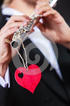 Male flutist with flute and heart. Love melody