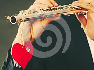 Male flutist with flute and heart. Love melody