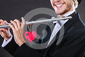 Male flutist with flute and heart. Love melody