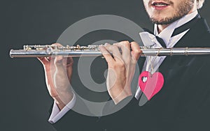 Male flutist with flute and heart. Love melody