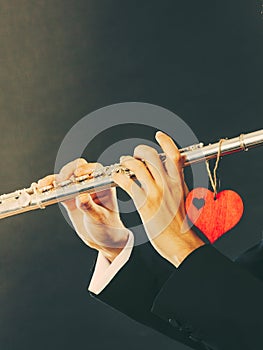 Male flutist with flute and heart. Love melody