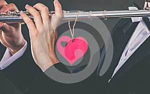 Male flutist with flute and heart. Love melody