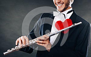 Male flutist with flute and heart. Love melody