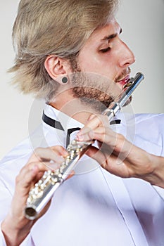 Male flutist playing his flute