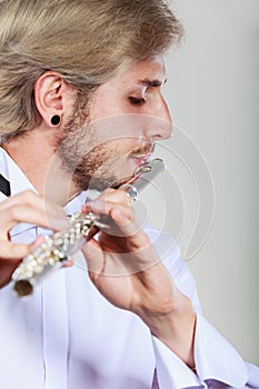 Male flutist playing his flute