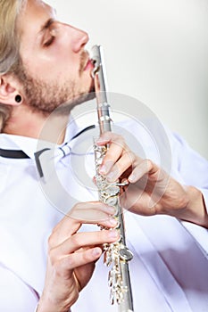 Male flutist playing his flute