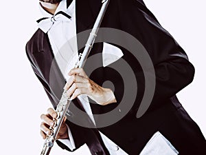 Male flutist wearing tailcoat holds flute