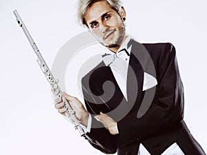 Male flutist wearing tailcoat holds flute