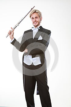 Male flutist wearing tailcoat holds flute