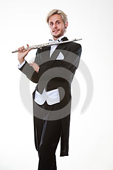 Male flutist wearing tailcoat holds flute