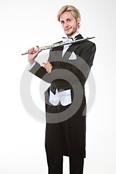 Male flutist wearing tailcoat holds flute