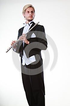 Male flutist wearing tailcoat holds flute