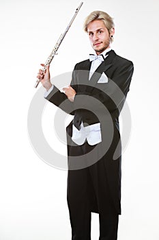 Male flutist wearing tailcoat holds flute