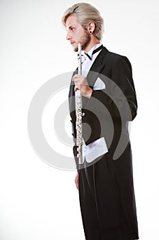 Male flutist wearing tailcoat holds flute