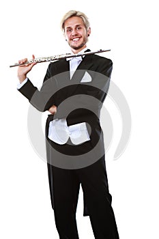 Male flutist wearing tailcoat holds flute