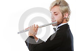 Male flutist wearing tailcoat plays flute