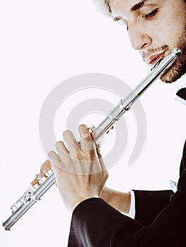 Male flutist wearing tailcoat plays flute