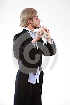 Male flutist wearing tailcoat plays flute