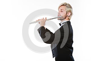 Male flutist wearing tailcoat plays flute