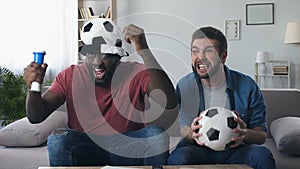 Male football fans roaring excitedly after national team scored goal, slow-mo