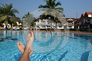 Male foots and swimming pool