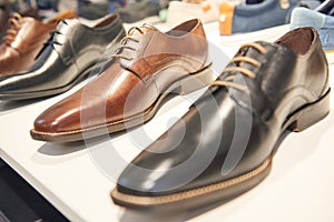 Male footwear selling. Formal leather shoes at shelf in shop window