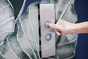 Male forefinger pressing on button in elevator lift.
