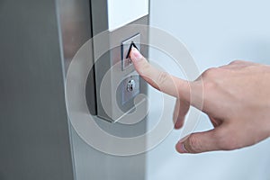 Male forefinger pressing on button up elevator