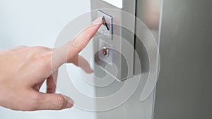 Male forefinger pressing on button up elevator