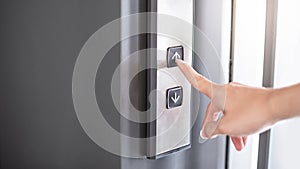 Male forefinger pressing on button up elevator
