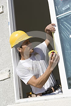 Male Foreman Taking Measure Of Window