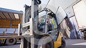 Male forklift driver working on loading and unloading goods in storehouse