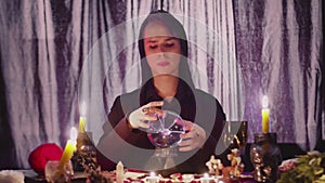 Male fortune teller performing ritual with crystal ball foreseeing future