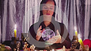 Male fortune teller performing ritual with crystal ball foreseeing future