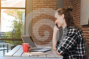 Male freelancer talk via smartphone use laptop in cafe, nomad co