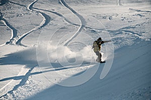 Male freeride snowboarder riding down the mountain snowcovered slope target the trace