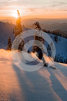Male freerider speedly ride down snow-covered slopes on fresh powder snow
