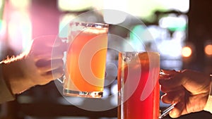 Male friends clinking with beer mugs in pub.